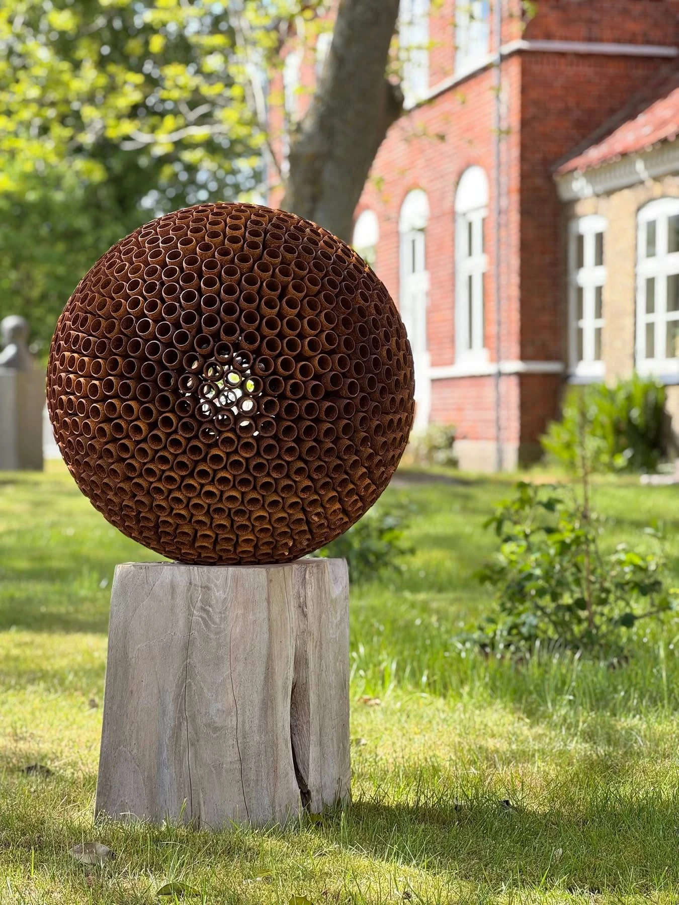 Unika skulptur med rør på teaktræssokkel